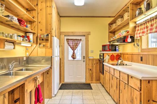 a kitchen with wooden cabinets and a white door at La Crescent Cottage on Minnesota Bluffs with View! in La Crescent