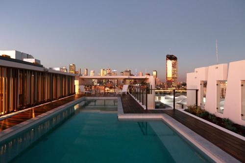 a swimming pool on top of a building with a city skyline at Opera Apartments South Brisbane in Brisbane