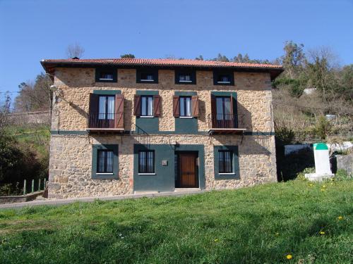 stary kamienny dom na szczycie wzgórza w obiekcie Casa Rural Enkartada w mieście Sopuerta