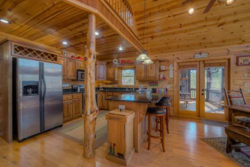 La cuisine est équipée d'un grand réfrigérateur et de placards en bois. dans l'établissement Hilltop Hideaway, à Blue Ridge