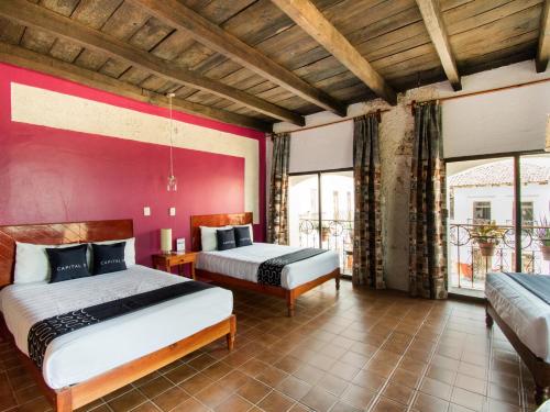 奎札蘭德波羅格雷索的住宿－Posada La Plazuela，红色墙壁的客房内的两张床