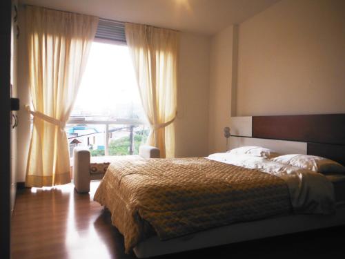 a bedroom with a bed and a large window at Beautiful Apartment Financial Zone-Fully Furnished in Lima