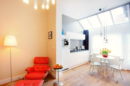 a living room with a red chair and a table at Blue Tulip Amsterdam in Amsterdam