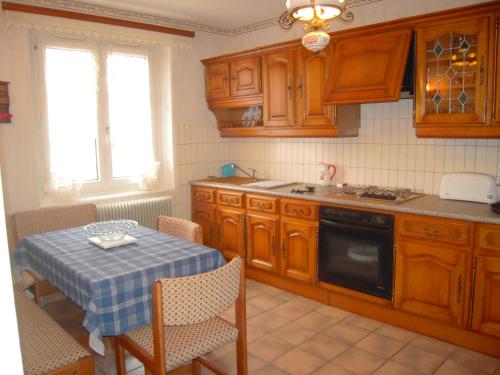 une cuisine avec des placards en bois et une table avec un chiffon bleu dans l'établissement Gîte du Moulin, à Ingersheim