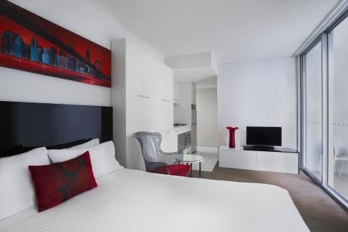 - une chambre avec un lit blanc et un oreiller rouge dans l'établissement Mantra Midtown, à Brisbane