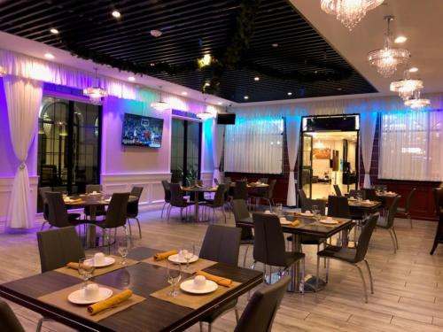 a dining room with tables and chairs and purple lighting at Holiday Inn El Monte - Los Angeles by IHG in El Monte