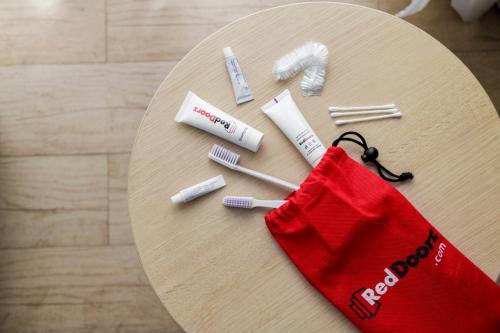 a table with toothbrushes and a red bag on it at RedDoorz near Lokawisata Baturaden 2 in Tenjo