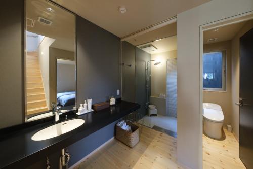 a bathroom with a sink and a toilet and a mirror at Kamome Jyuku in Takamatsu