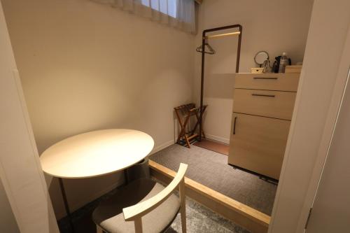 a small room with a table and a dresser at GEN HOTEL KAMAKURA in Kamakura