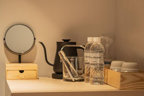 a table with a mirror and a bottle on it at GEN HOTEL KAMAKURA in Kamakura