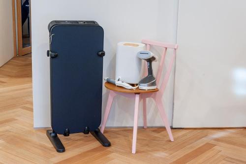 a black suitcase sitting next to a small table at plat hostel keikyu haneda home in Tokyo