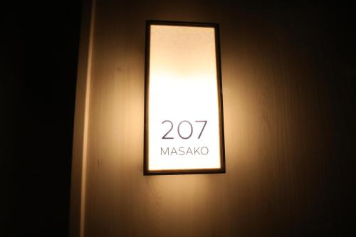 a light on a wall with a sign on it at GEN HOTEL KAMAKURA in Kamakura