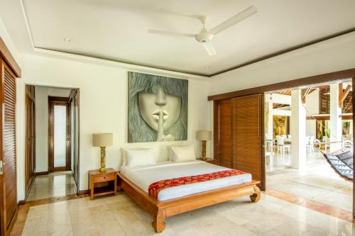1 dormitorio con 1 cama y una pintura en la pared en Villa Maharaj, en Seminyak