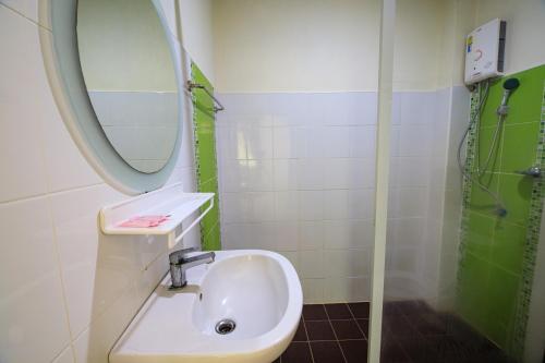 La salle de bains est pourvue d'un lavabo, d'un miroir et d'une douche. dans l'établissement วันสุขรีสอร์ทสุโขทัย, à Ban Khlong Takhian