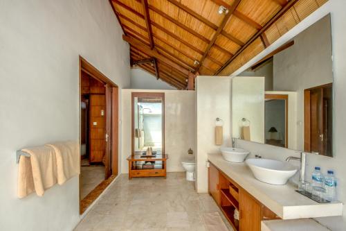 La salle de bains est pourvue de 2 lavabos et d'un miroir. dans l'établissement Villa Maharaj, à Seminyak