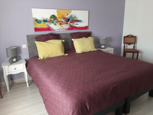 a bedroom with a bed with a purple comforter at LE PRESSOIR in Mercurol