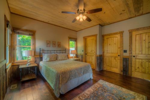 Schlafzimmer mit einem Bett und einem Deckenventilator in der Unterkunft Little Bird Landing in Blue Ridge