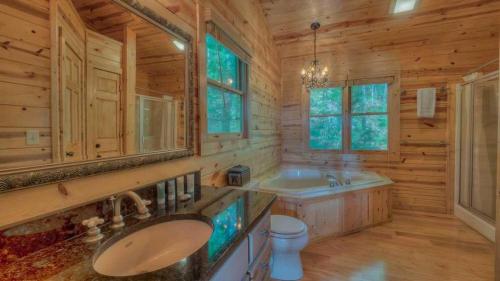 Un baño de cabaña de madera con lavabo e inodoro. en Majestic Sunrise, en Blue Ridge