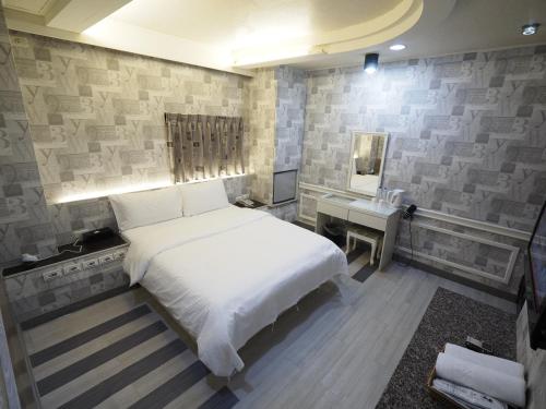 a bedroom with a bed and a desk and a mirror at 合悅都會商旅 Heyue HOTEL in Hsinchu City