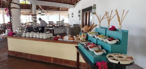 a kitchen with a counter with plates of food at The ONE in Watamu