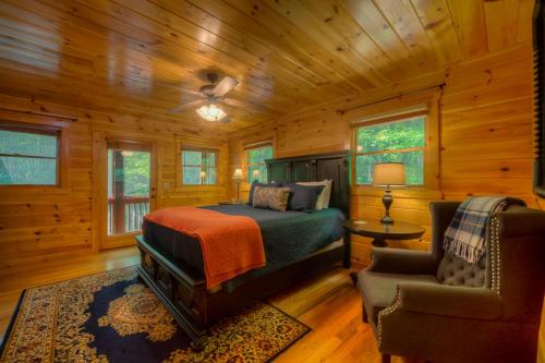 1 dormitorio con 1 cama y 1 silla en una cabaña en Our Blue Heaven, en Blue Ridge