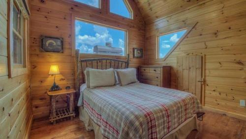Un dormitorio con una cama en una cabaña de madera. en Panoramic Grace, en Blue Ridge