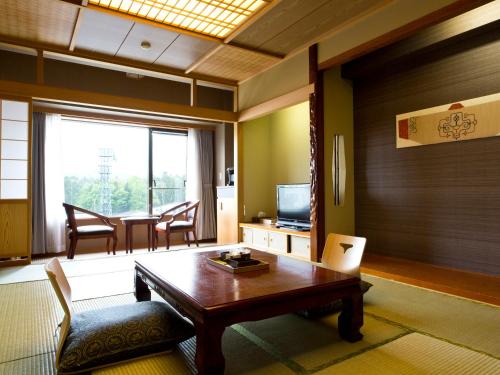 a living room with a wooden table and a television at Lake Akan Tsuruga Wings in Akankohan