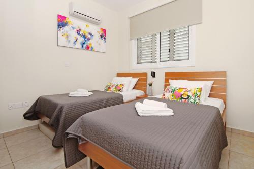 - une chambre avec 2 lits et des serviettes dans l'établissement Apartment Mariada, à Paralímni