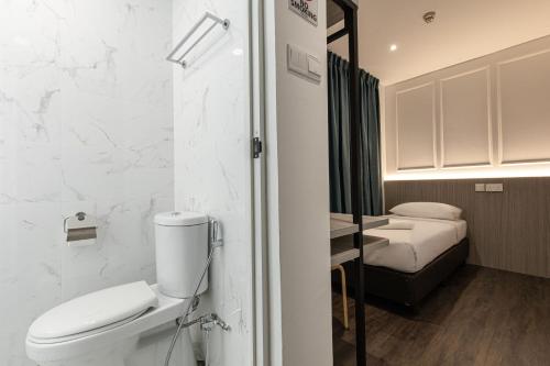 bagno bianco con servizi igienici e lavandino di Philip Hotel a Singapore