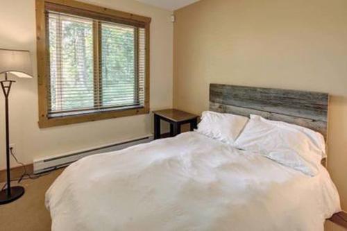 a bedroom with a white bed and a window at Chalet Mont Tremblant Luxury Lodge in Labelle