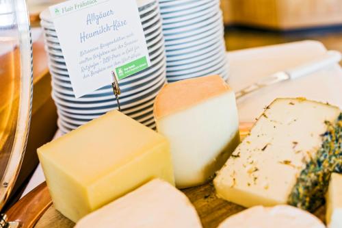 a plate of cheeses and plates on a table at Flair Hotel zum Schiff in Meersburg