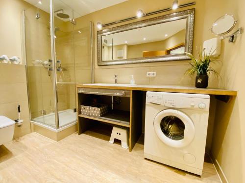 a bathroom with a washing machine and a mirror at Ferienwohnung - Strandoase in Heringsdorf