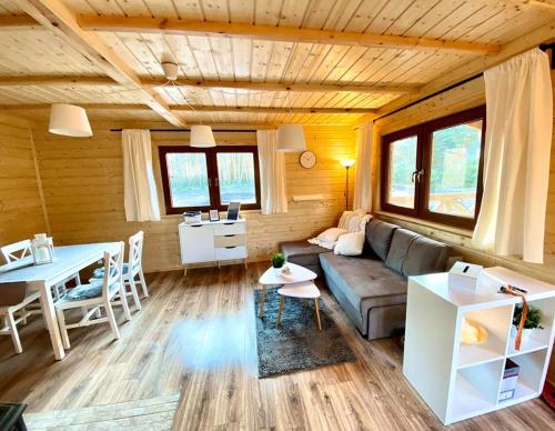 ein Wohnzimmer mit einem Sofa und einem Tisch in der Unterkunft Domki w Lipnicy in Lipnica