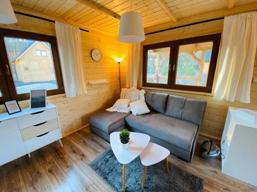 ein Wohnzimmer mit einem Sofa und einem Tisch in der Unterkunft Domki w Lipnicy in Lipnica