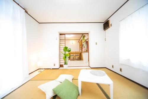 a living room with a white table and chairs at Higashiomi Large House in Higashiomi