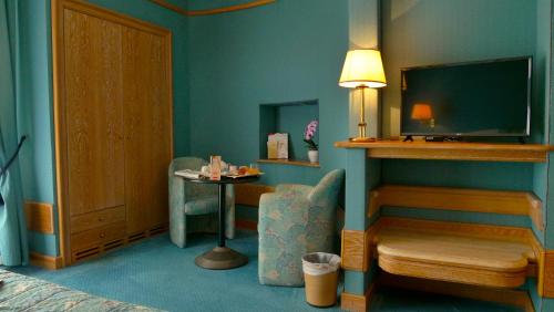 a room with a bed and a tv and a chair at 501 Hotel in Vibo Valentia