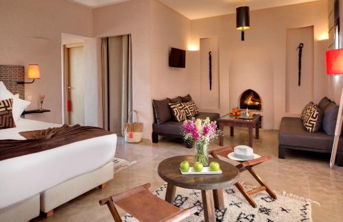 une chambre d'hôtel avec un lit et un salon dans l'établissement Oasis lodges, à Marrakech