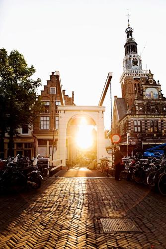 a building with the sun shining through a brick street at Kings Inn City Hotel Alkmaar in Alkmaar