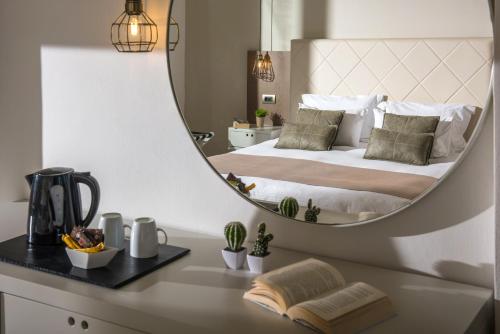 a bedroom with a bed with a mirror on it at Gouves Bay by Omilos Hotels in Gouves