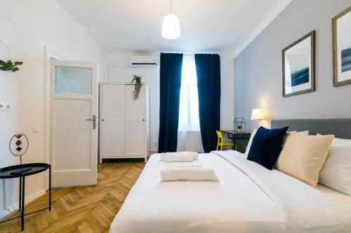 a bedroom with a large white bed with blue curtains at CATCHY DREAMS Spacious & Homey Apartment in Bucharest