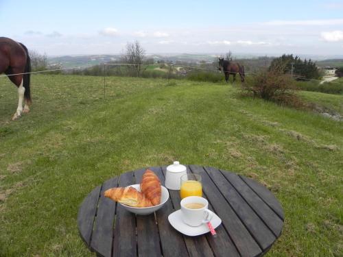 - une table avec un plateau de croissants, du café et un bol de pain dans l'établissement Magnolia résidence Domaine Cap de Coste, à Saint-Frajou