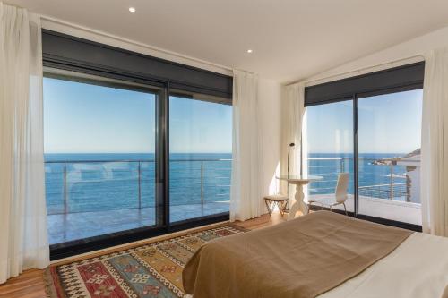 ein Schlafzimmer mit Bett und großen Fenstern in der Unterkunft Flateli Port de la Selva in Port de la Selva
