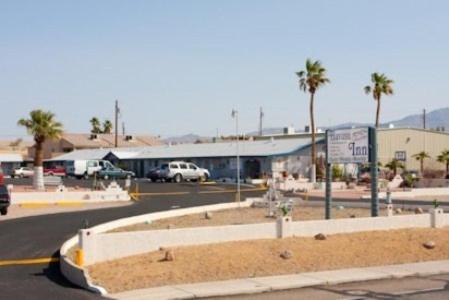 een parkeerplaats met palmbomen en een gebouw bij Havasu Inn & Suites in Lake Havasu City