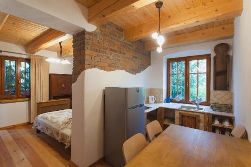 a kitchen with a table and a refrigerator in a room at Apartamenty Batur in Karpacz