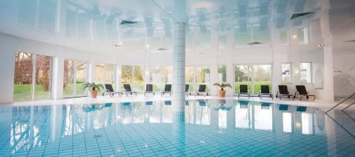 ベーツステルズワーグにあるLandgoed Lauswoltの建物内に椅子のある大きなプール