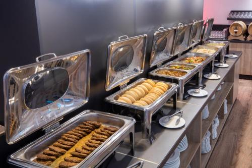 a buffet line with trays of food and pastries at SOWELL HOTELS Mont Blanc et SPA in Saint-Gervais-les-Bains