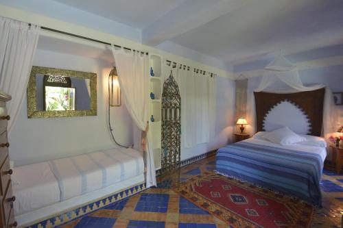a bedroom with a bed and a mirror at Riad Des Plages in Bouznika