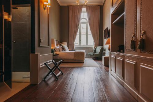 a living room with a bed and a window at Torel 1884 Suites & Apartments in Porto