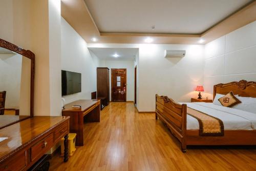 a bedroom with a bed and a desk and a television at Hoang Duc Hotel in Chau Doc