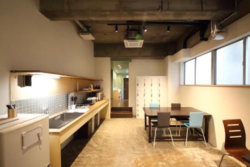 a large kitchen with a table and chairs in it at Guesthouse & Lounge FARO in Iwaki